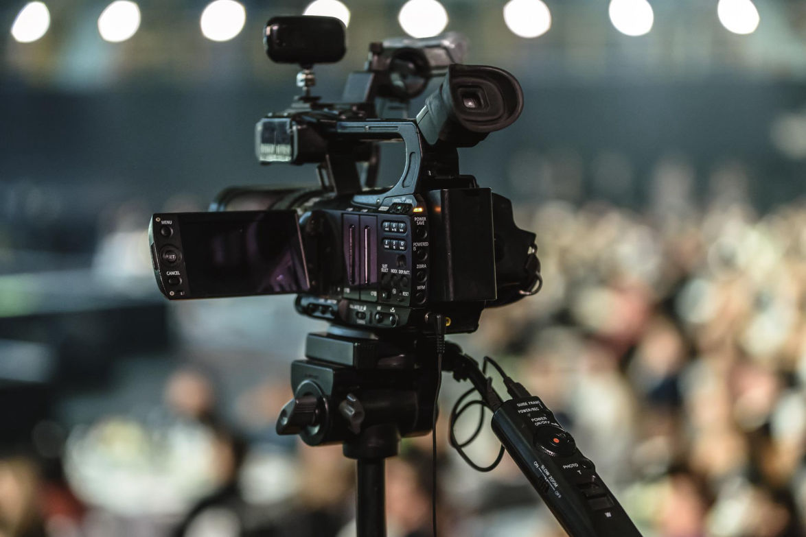 digital film camera on tripod shooting audience